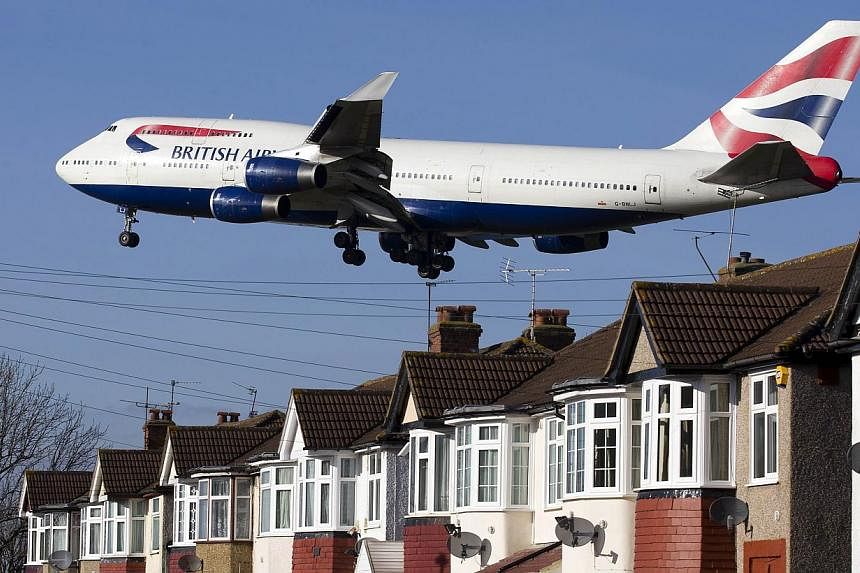 A British Airways 747 aircraft flies over roof tops as it comes into lane at Heathrow Airport in west London on Feb 18, 2015. The airline is celebrating the birth of Britain's new royal baby by offering Singapore travellers promotional fares to Londo