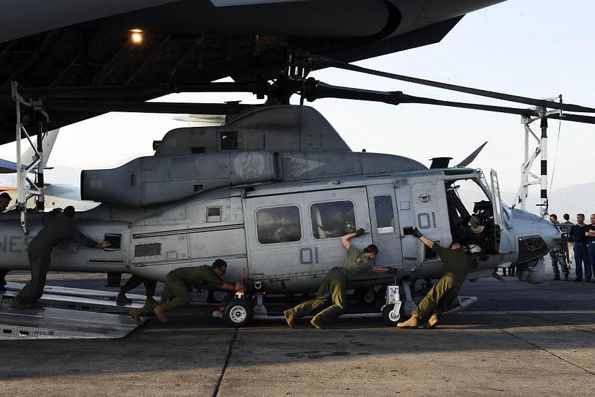 The crew of a US C-17 military transport plane unload a Huey helicopter at Kathmandu's international airport on May 3, 2015.&nbsp;United States transport aircraft were to begin shuttling rescue teams and supplies on Monday to remote areas of Nepal th