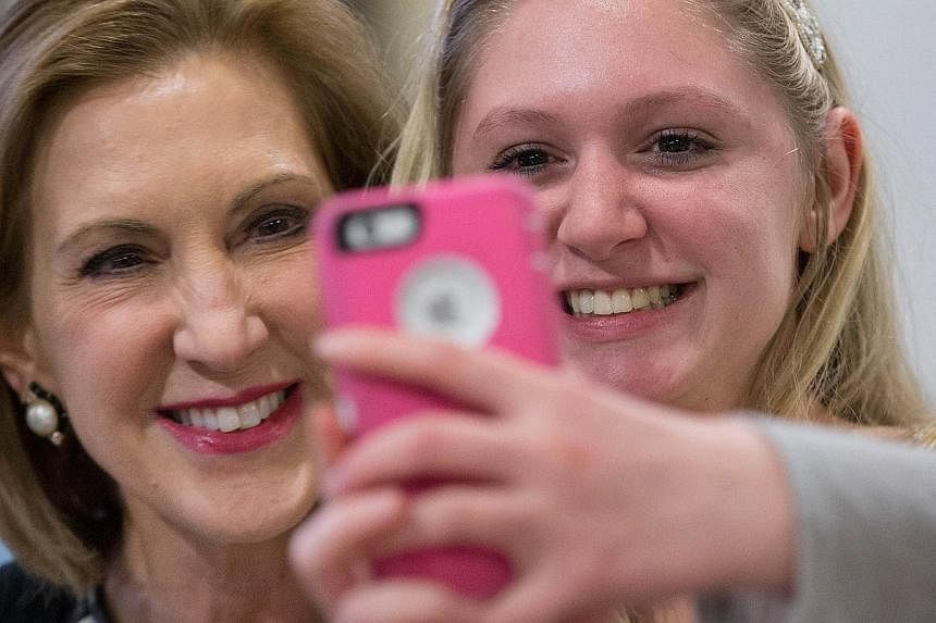 Mrs Carly Fiorina (left) posing for a selfie with a supporter at a Republican event at a high school in Iowa last month. Her mixed record at HP is under scrutiny ahead of her expected presidential bid today.