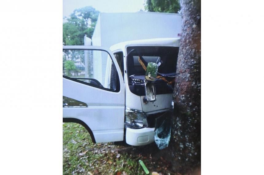 At least one man has died in an accident after a lorry slid during wet weather and hit a tree at Yishun Avenue 1 on Sunday morning. -- PHOTO: SHIN MIN