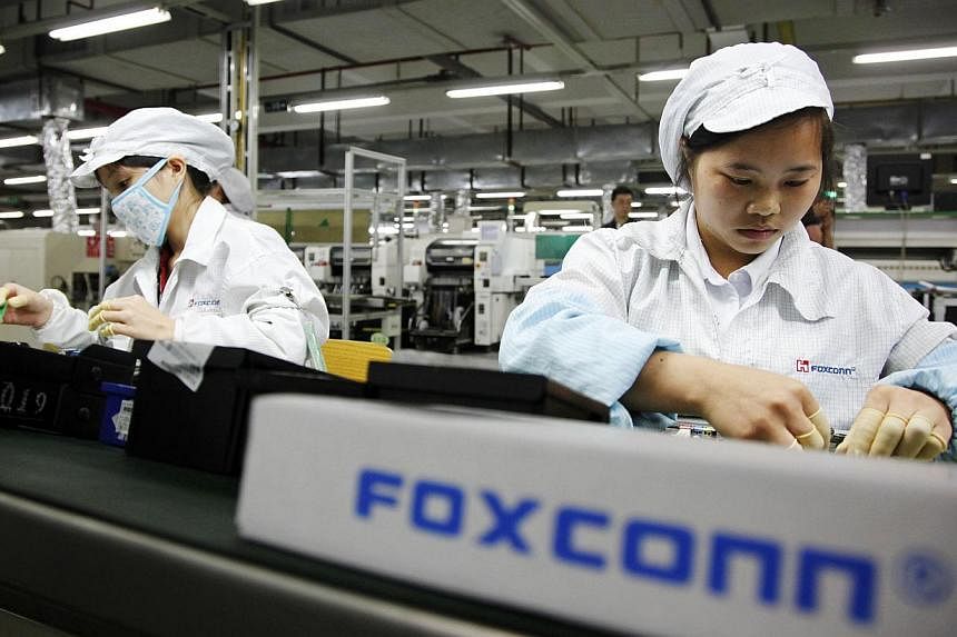 Employees work on the assembly line at Taiwanese manufacturer Foxconn's plant in Shenzhen, China. -- PHOTO: BLOOMBERG&nbsp;