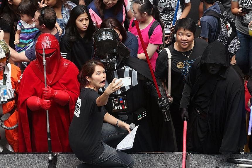 Stage and floor emcee Ms Joanne Su (centre), 32, gets a selfie taken with Darth Vader as members of the public and fans of Star Wars attend the Star Wars Day "Celebrate the Force" event held at Suntec City, east wing atrium on May 2, 2015. The two-da