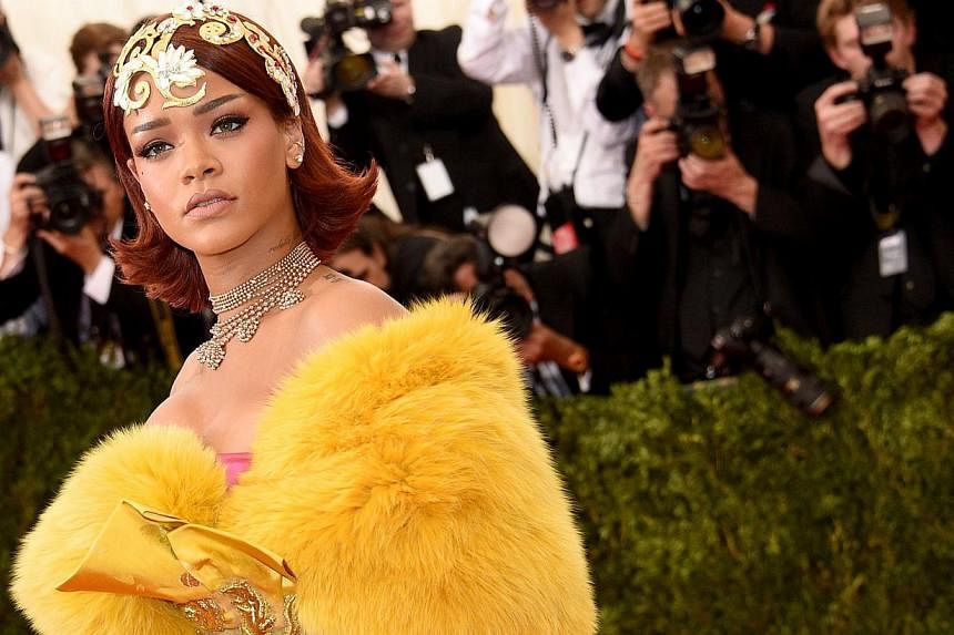 Rihanna wearing a gold tiara and flowing yellow robe at the New York Met Ball on May 4, 2015. The city's party of the year, attended by stars such as Madonna, George Clooney, Sarah Jessica Parker and Robert Pattinson, chose China as the theme of its 
