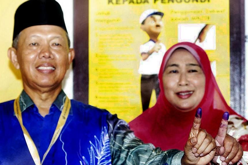 Both Datuk Hasan Arifin and wife Datin Rozidah Ab Karim showing their fingers marked with the voting ink. -- PHOTO: THE STAR