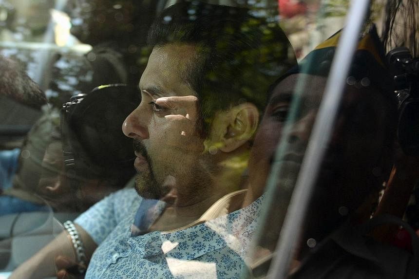 In this file photograph taken on May 6, 2014, Indian Bollywood film actor Salman Khan leaves in a car after appearing at the sessions court in Mumbai. Bollywood star Salman Khan, known for his bulging biceps and off-camera temper tantrums, faces jail