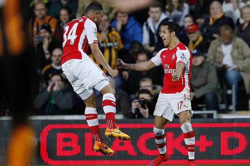 Arsenal forward Alexis Sanchez (right) celebrates with teammate Francis Coquelin after opening the scoring against Hull. -- PHOTO: REUTERS