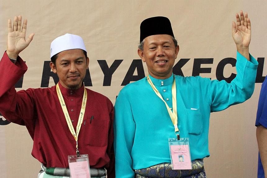 Mr Nazri Ahmad (left) of Parti Islam seMalaysia (PAS) and Datuk Hasan Arifin of Barisan Nasional (BN), the two candidates for the Rompin by-election, waving to their supporters. Polling for the by-election closed at 5pm, with voter turnout standing a