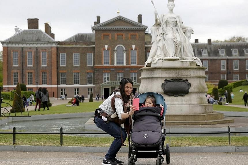 Nenita Soper poses for a selfie with her daughters Charlotte (centre) and Olive outside Kensington Palace in London on Monday as Britain's new princess was named Charlotte Elizabeth Diana. -- PHOTO:&nbsp;REUTERS