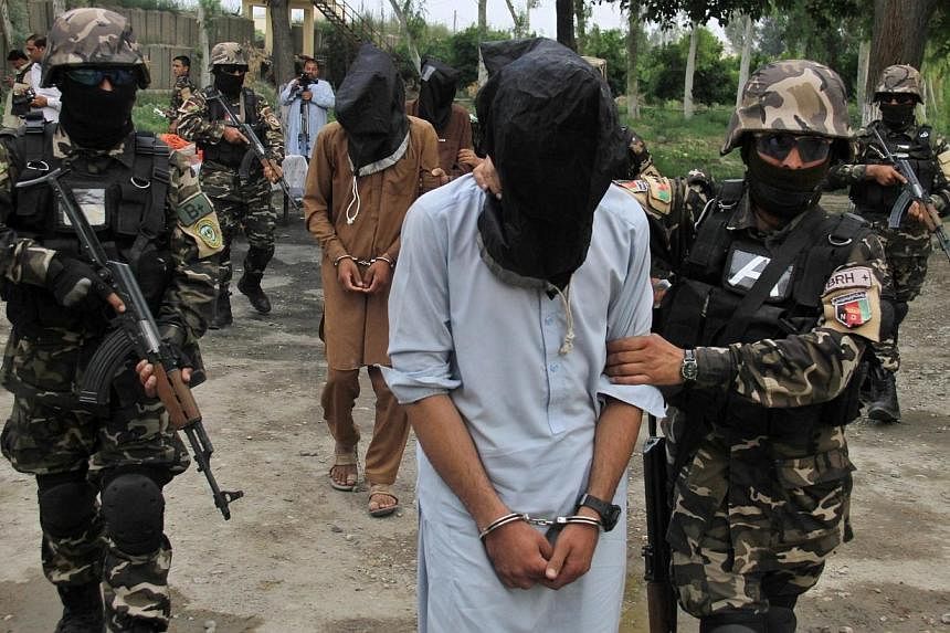 Members of the Afghan National Directorate of Security (NDS) escort four suspected Taleban members allegedly involved in criminal activities in the area, after their arrest in Jalalabad, Afghanistan on Monday. -- PHOTO: EPA