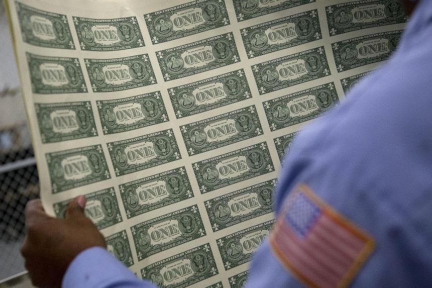 A one dollar note sheet is inspected at the US Bureau of Engraving and Printing in Washington, DC, on April 14, 2015. The Republican-led United States Congress passed a 2016 Budget on Tuesday, a largely symbolic policy document which if fully enacted