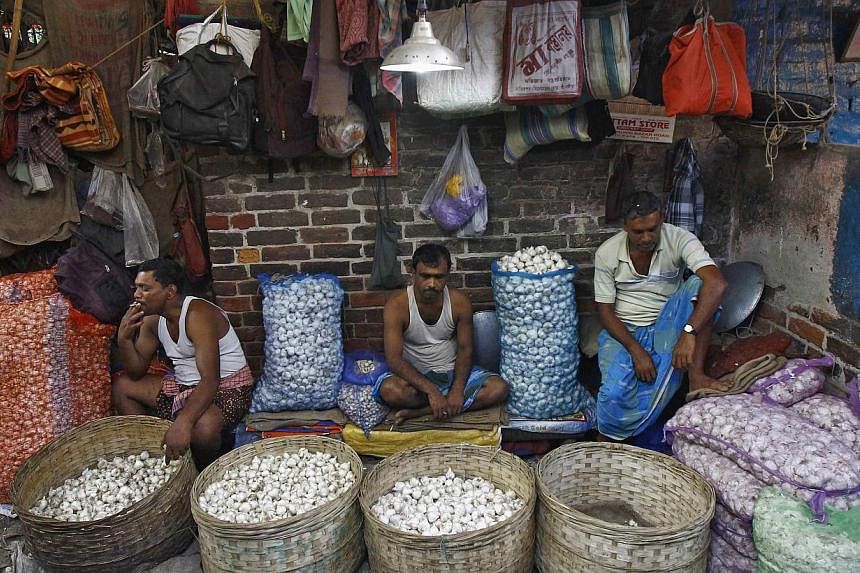 Garlic vendors waiting for customers at their stall at a wholesale vegetable market in Kolkata on Feb 27, 2015. India's lower house of parliament passed a bill on Wednesday, May 6, that seeks to transform the country into a common market with a singl