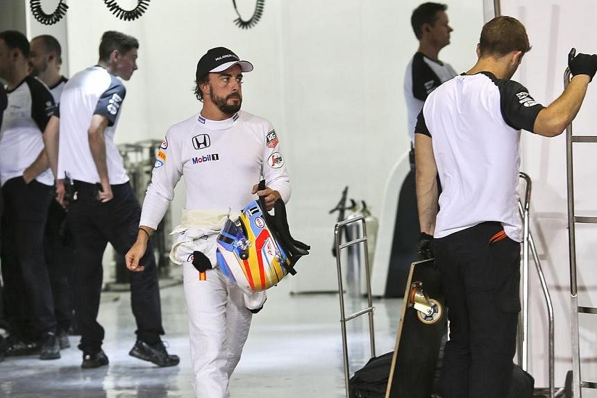 McLaren Honda Spanish driver Fernando Alonso walks down the pit during the qualification session for the Bahrain Formula One Grand Prix on April 18, 2015. -- PHOTO: AFP