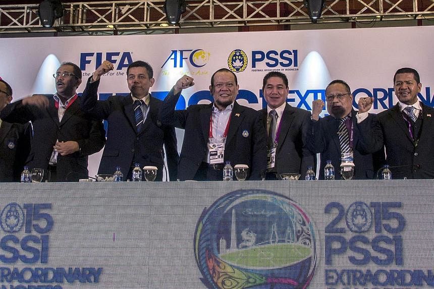 This photo taken on April 18, 2015 shows newly-elected Indonesian Football Association (PSSI) chief La Nyalla Mattalitti (fourth left) standing with new officials of the PSSI following his election in Surabaya, East Java province. FIFA has ordered th