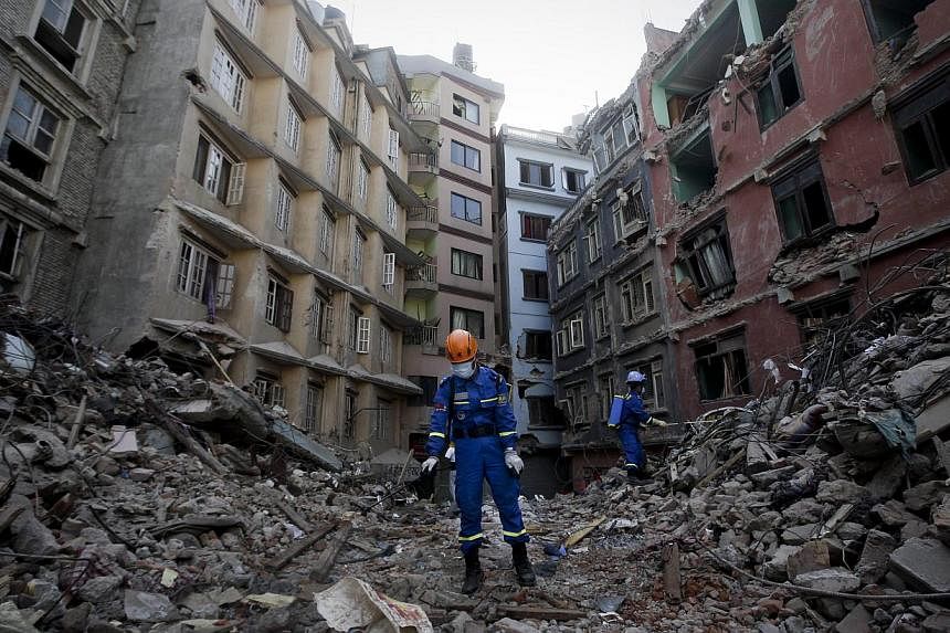 Members of a Chinese recovery team disinfect debris from destroyed buildings in Balaju, Kathmandu, after the devastating earthquake that hit the country on April 25, 2015. -- PHOTO: EPA&nbsp;