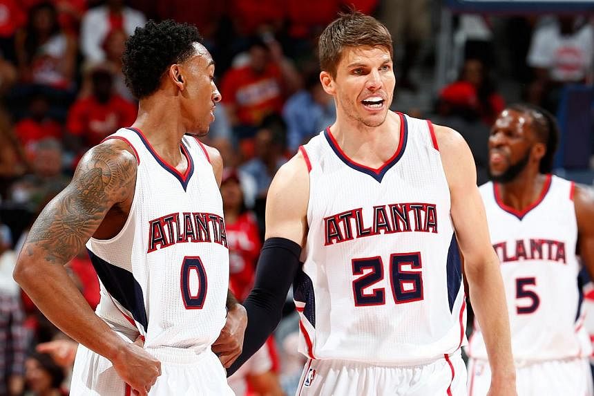 Kyle Korver (centre) of the Atlanta Hawks converses with Jeff Teague (left) during Game Two of the Eastern Conference Semifinals against the Washington Wizards at the Philips Arena, Atlanta, Georgia, on May 5, 2015. -- PHOTO: AFP &nbsp;