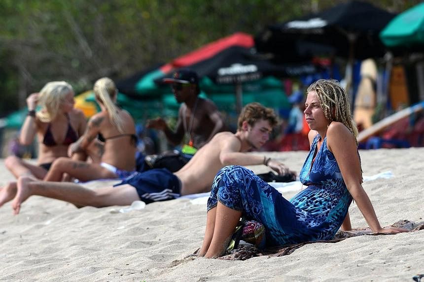 Foreign tourists sunbathing on Kuta beach, Bali island on March 17, 2015.&nbsp;The number of Australian visitors to Indonesia rose in March and the island nation's tourism industry has seen no impact from a Boycott Bali protest over death sentences p