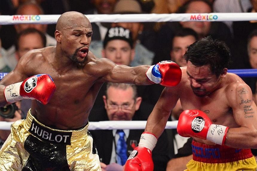 Floyd Mayweather (left) connecting against Manny Pacquiao during their bout on May 2, 2015, at the MGM Grand Garden Arena in Las Vegas, Nevada. -- PHOTO: AFP&nbsp;
