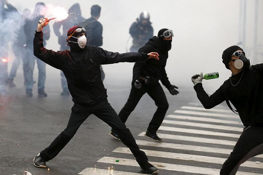 Protesters throwing bottles and flares during a rally against Expo 2015 in Milan, Italy, on May 1, 2015. Swiss watchmaker Rolex demanded an apology from the Italian government saying that the latter had damaged the former's reputation by portraying t