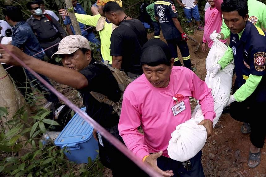 Thai rescue workers collect the recovered remains of a suspected Rohingya migrant after discovering another grave site at a long-abandoned Muslim cemetery in Sadao district, Songkhla province near the Thai-Malaysian border in southern Thailand on May