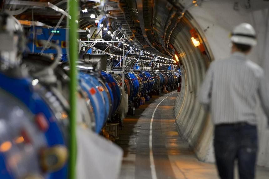 A scientist walks in a tunnel inside the European Organisation for Nuclear Research (CERN) Large Hadron Collider (LHC), during maintenance works on July 19, 2013 in Meyrin, near Geneva. -- PHOTO: AFP