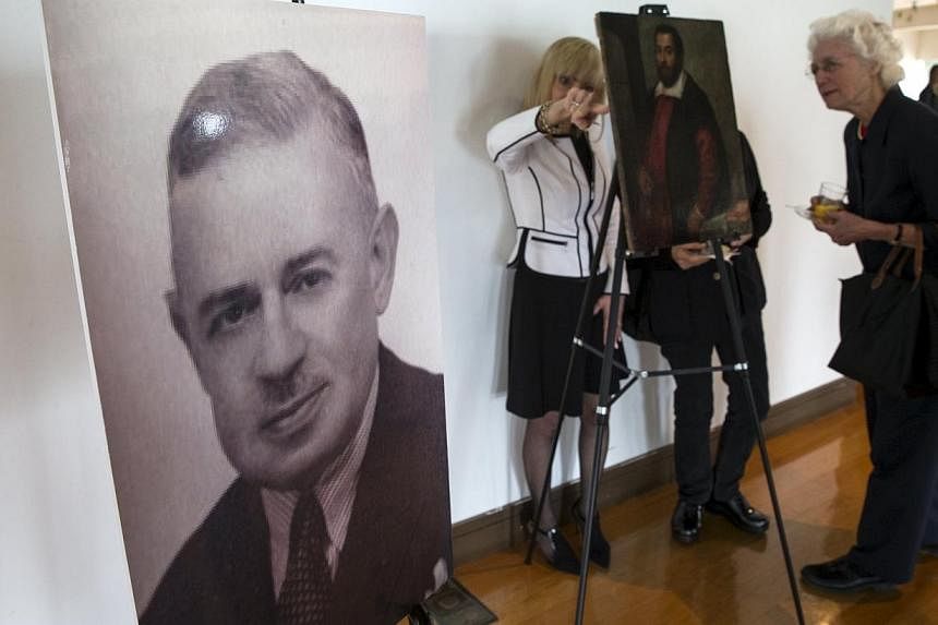 A photograph of German Holocaust victim Dr. August Liebmann Mayer, stands next to the 17th century painting Portrait of a Man which belonged to Dr Mayer at a ceremony at the Jewish Heritage Museum in New York officially returning the painting to Maye