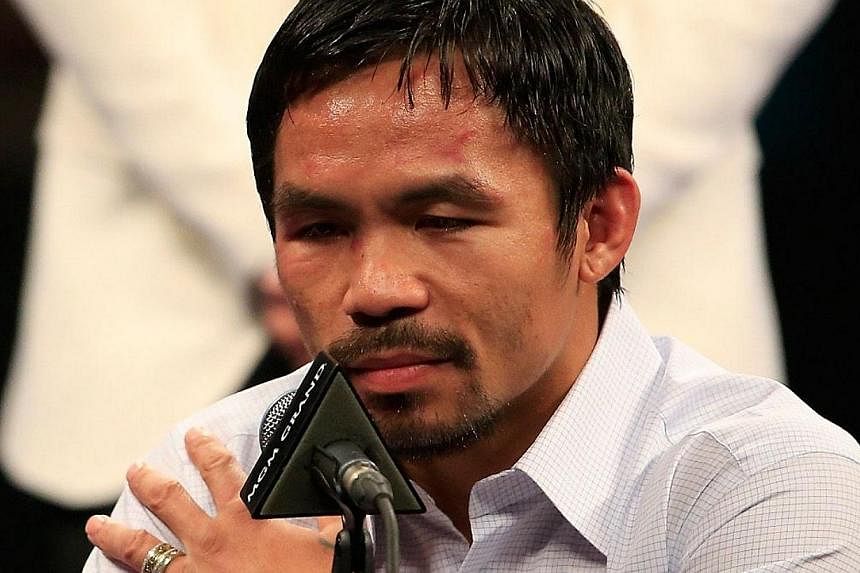 Manny Pacquiao points to his right shoulder during the post-fight news conference after losing to Floyd Mayweather Jr. in their welterweight unification championship bout on May 2, 2015 at MGM Grand Garden Arena in Las Vegas, Nevada. -- PHOTO: AFP