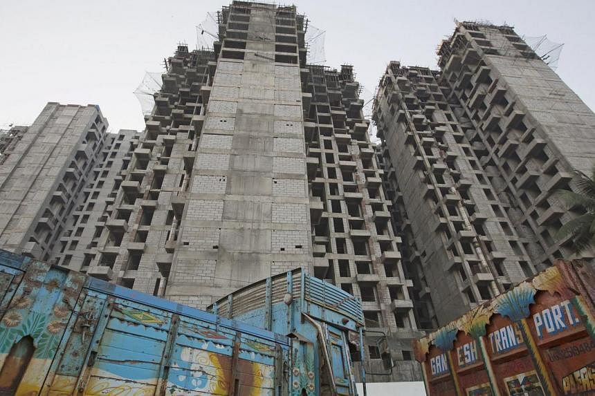 Trucks are parked at the site of an under-construction residential building project in Mumbai on March 19, 2015. India's federal cabinet on Wednesday relaxed rules to allow foreign funds to invest in real estate investment trusts (Reits), a move desi
