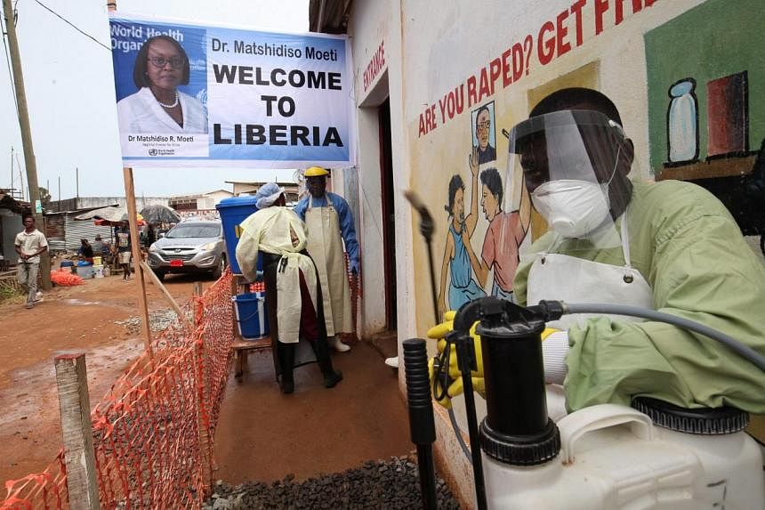 Health workers at the entrance of the Redemption Hospital in Newkru town in a surburb of Monrovia, Liberia, on April 22, 2015. -- PHOTO: EPA