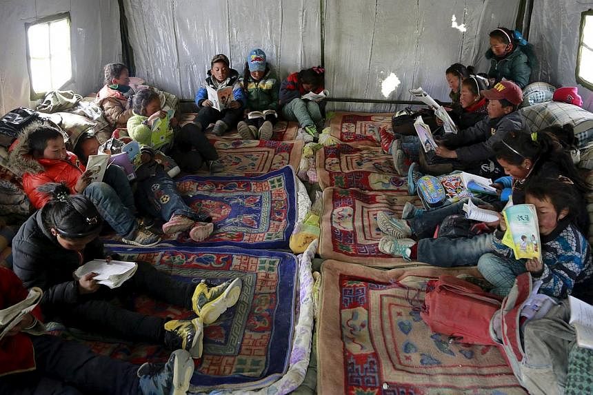 Third-grade students read in a class at a relief tent after the 7.9-magnitude earthquake hit Nepal. The earthquake has left almost a million children without classrooms, the UN children's agency says, calling for urgent action to repair damaged schoo