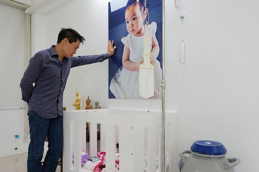 Dr Sahatorn Naovaratpong, a businessman, at the cot where his daughter, Matheryn, used to sleep when she was battling brain cancer, until her death in January 2015. -- ST PHOTO: TAN HUI YEE