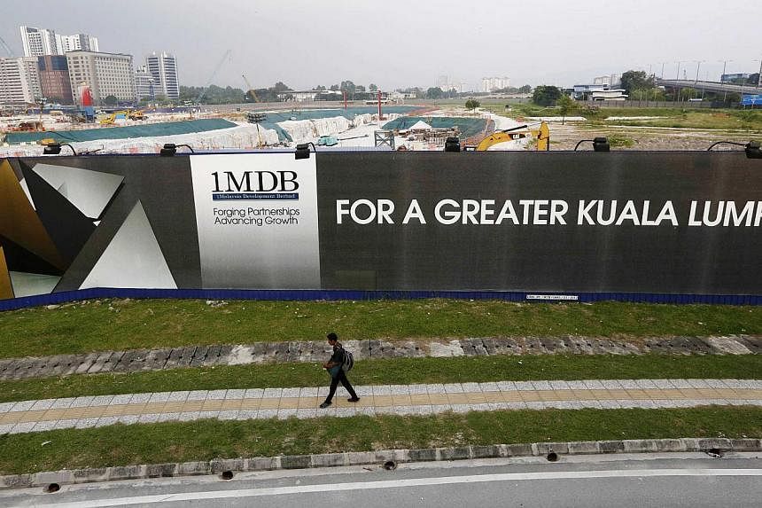 A man walks past a 1 Malaysia Development Berhad (1MDB) billboard at the funds flagship Tun Razak Exchange development in Kuala Lumpur on March 1, 2015. -- PHOTO: REUTERS&nbsp;