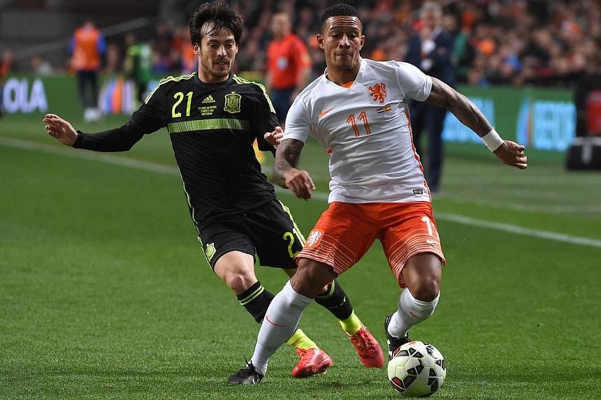 Memphis Depay (right) vies with Spain's David Silva during the friendly football match Netherlands vs Spain in Amsterdam, on March 31, 2015. -- PHOTO: AFP &nbsp;