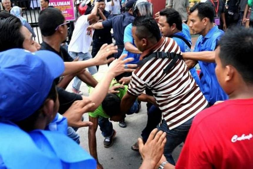 Rival supporters clash outside SK Tanah Liat polling centre during the Permatang Pauh by-election. -- PHOTO: THE STAR/ASIA NEWS NETWORK&nbsp;