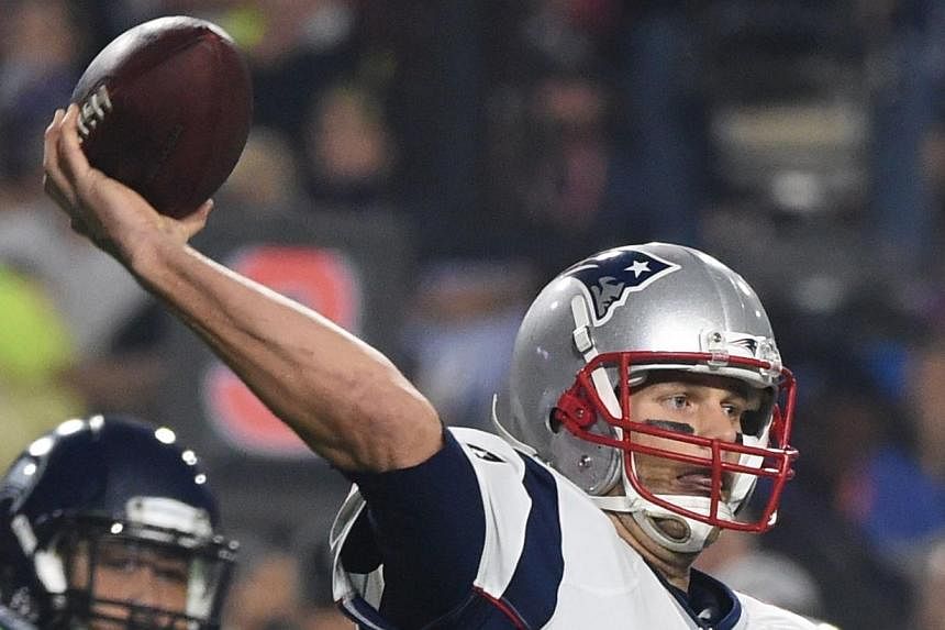 Quarterback Tom Brady (centre) of the New England Patriots prepares to pass against the Seattle Seahawks during Super Bowl XLIX in this February 1, 2015, file photo, at the at University of Phoenix Stadium in Glendale, Arizona. -- PHOTO: AFP