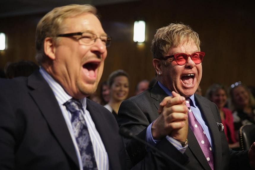 Singer/songwriter Elton John (right) and pastor of the Saddleback Church Rick Warren (left) shake hands prior to a hearing before the State, Foreign Operations and Related Programs Subcommittee of the Senate Appropriations Committee on Tuesday on Cap