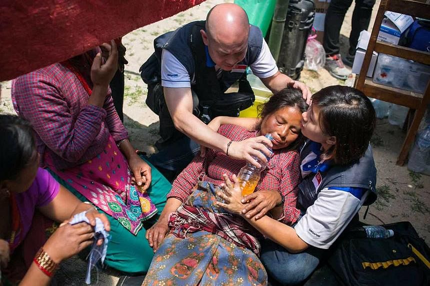 Quake survivors preparing a meal at an open-ground shelter area in Kathmandu on Tuesday. For those forced to camp outside, relief organisations say tarpaulins are more suitable than tents, which can weigh up to 80kg. Mercy Relief Singapore chairman M