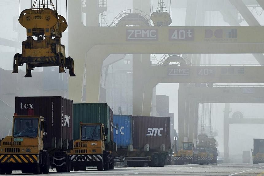 Shipping containers are loaded onto trucks at Dayaowan port in Dalian, Liaoning province, in 2012. China's exports shrank in April, adding downward pressure on an economy grappling with overcapacity and a property slump. -- PHOTO: REUTERS