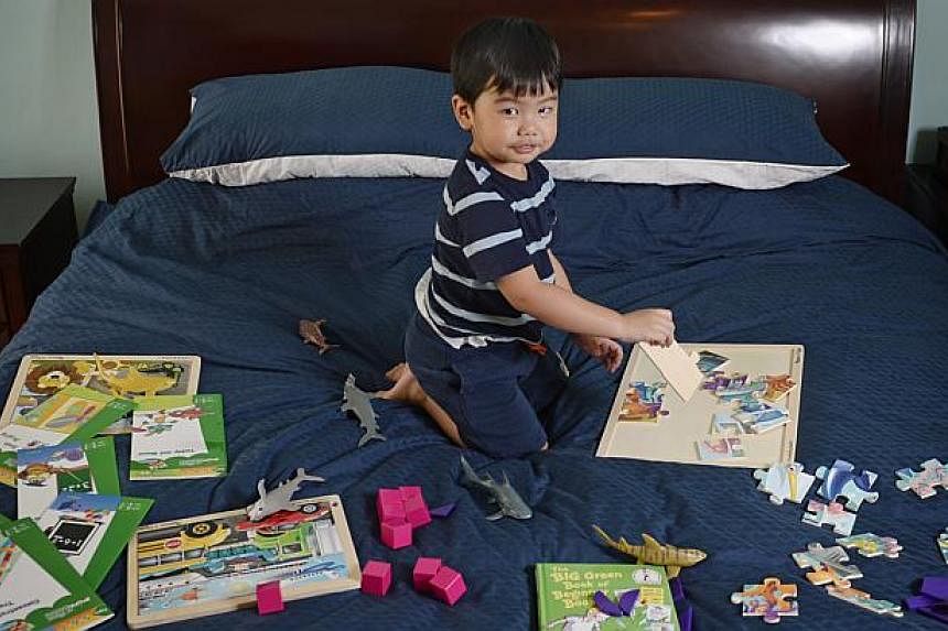 Elijah Catalig, at an age of two years and six months, is currently the youngest member in Mensa Singapore. He is pictured at home with some of his puzzles, games and activity books on May 7, 2015. -- ST PHOTO: MARK CHEONG