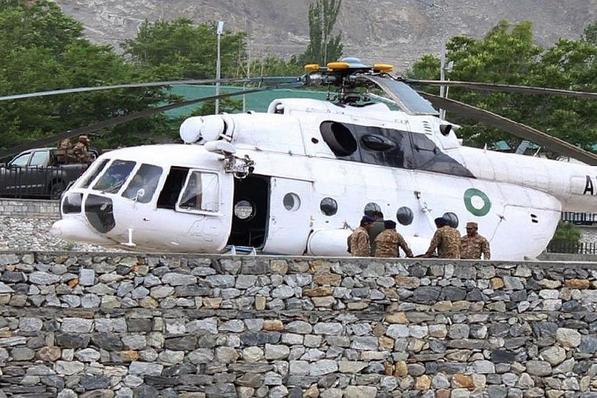 Pakistani soldiers gather beside an army helicopter at a military hospital where victims of a helicopter crash were brought for treatment in Gilgit on May 8, 2015. -- PHOTO: AFP&nbsp;