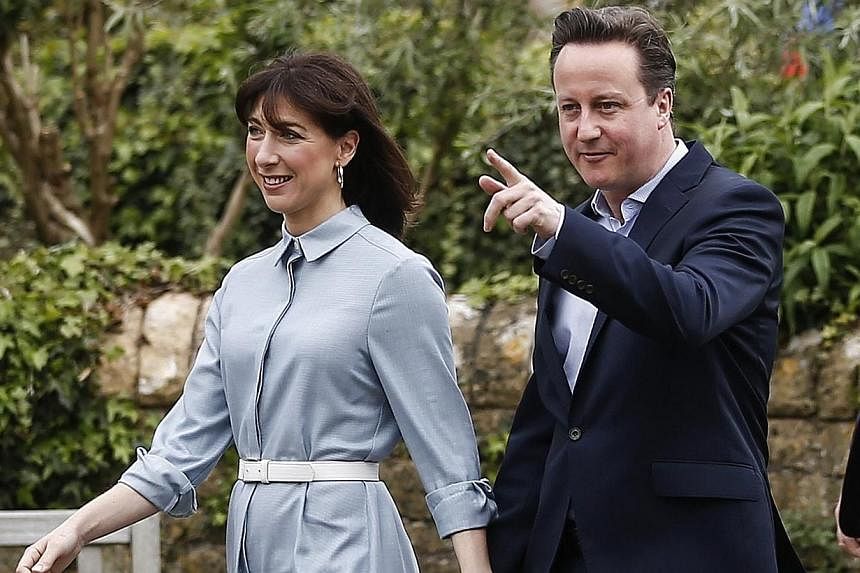 Mr David Cameron, British prime minister and leader of the Conservative Party, center right, and Mrs Samantha Cameron, his wife, leave after casting their votes in the general election at a polling station in Spelsbury on Thursday. Cameron's&nbsp;Con