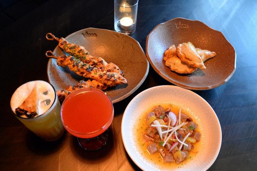 Offerings at Vasco include (above clockwise from left) signature cocktails Hand Of God and Cusco Puta and snacks chicken pincho, lamb empanadas and tuna ceviche. -- ST PHOTO: AZIZ HUSSIN
