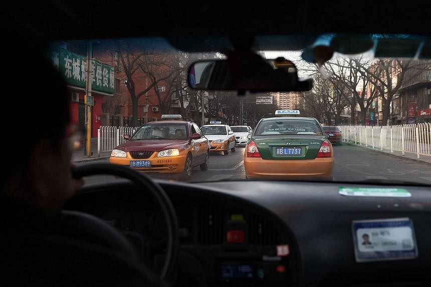 A Feb 16, 2015 photo shows a taxi driver following another taxi on a street in Beijing. China's crackdown on ride-sharing app Uber may have less to do with protecting the owners of politically powerful taxi services than placating the taxi industry's