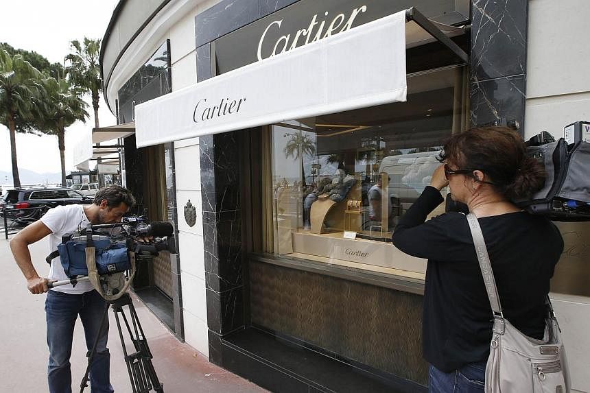 Journalists work in front of the Cartier jewellery shop on the Croisette in Cannes, French Riviera, on May 5, 2015, after the hold up by four armed men who fled with a large amount of jewellery.With France still on high alert after January's attacks 