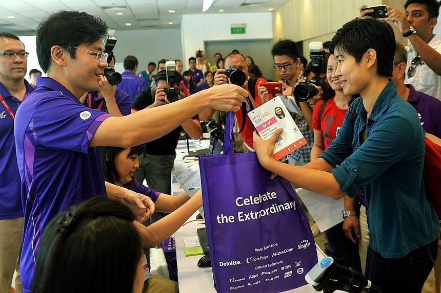 Volunteer Miss Yee Si Hui 21, received the Sea Games bag from Culture, Community and Youth Minister Lawrence Wong.&nbsp;-- PHOTO: BERITA HARIAN&nbsp;