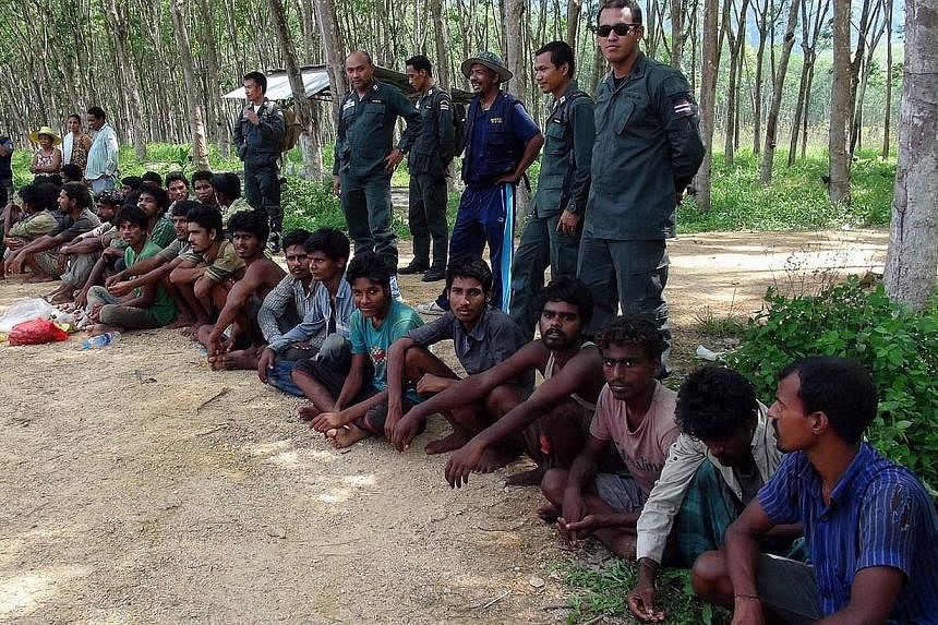 Migrants, believed to be from Myanmar and Bangladesh, sit after they were detained by police in the southern Thai province of Songkhla on May 8, 2015. -- PHOTO: AFP
