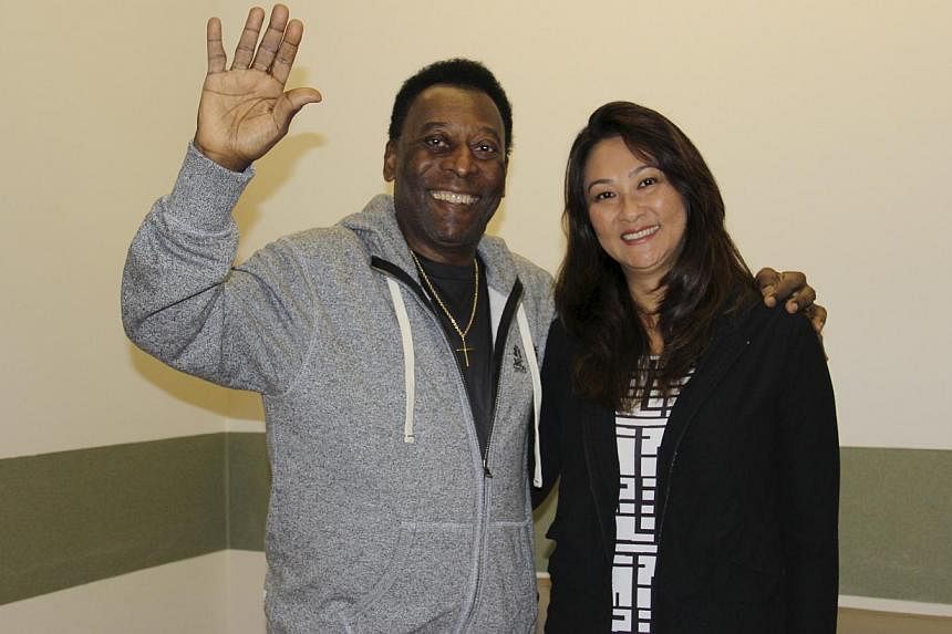Pele (left) waves with his wife Marcia Cibele Aoki at the Albert Einstein Hospital in Sao Paulo in this May 9, 2015 handout photograph from his family, courtesy of the hospital. The Brazilian soccer legend left hospital on Saturday after undergoing p