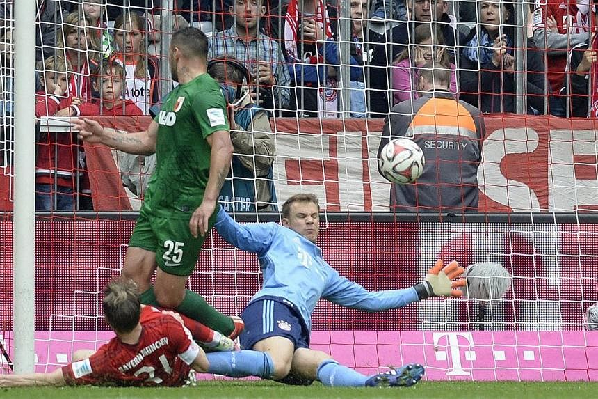 Augsburg's Argentinian striker Raul Bobadilla (centre) shoots the goal for Augsburg against Bayern Munich's midfielder Bastian Schweinsteiger (left) and Bayern goalkeeper Manuel Neuer (right) on May 9, 2015. Augsburg won the match 0-1. -- PHOTO: AFP
