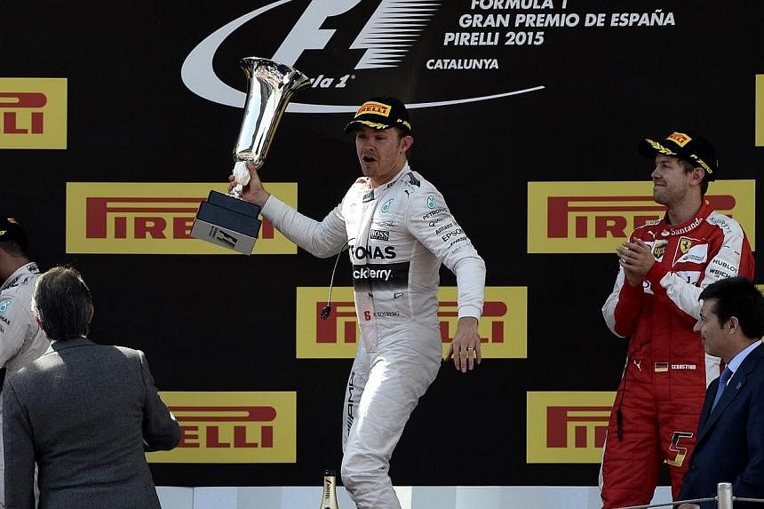 Mercedes' Nico Rosberg (centre) of Germany celebrates his win at the Spanish Grand Prix with Ferrari's German driver Sebastian Vettel (right) and Mercedes' British driver Lewis Hamilton (left)&nbsp;at the Circuit de Catalunya in Montmelo on May 10, 2