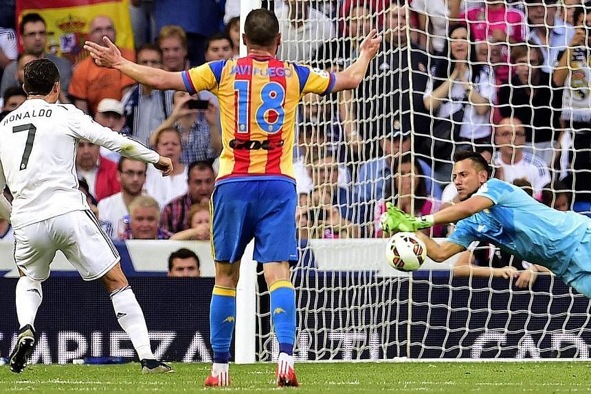 Valencia's goalkeeper Diego Alves (right) stops a penalty kick shot by Real Madrid's Portuguese forward Cristiano Ronaldo (left)&nbsp;on May 9, 2015. -- PHOTO: AFP