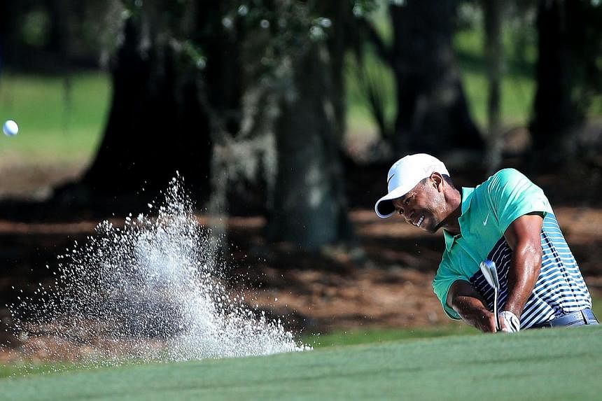 Tiger Woods plays a shot from a bunker on the second hole during round three of the Players Championship at the TPC Sawgrass Stadium course on May 9, 2015. -- PHOTO: AFP&nbsp;